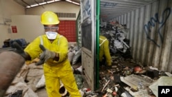 FILE - Workers unload and sort through a container full of electronic waste that was collected from a Nairobi slum and brought in for recycling, at the East African Compliant Recycling facility in Machakos, near Nairobi, in Kenya, Aug. 18. 2014.