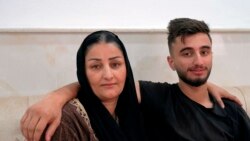 Sarkawt Selim, 19, who returned recently from Minsk after failing to cross the border into Poland, sits with his mother Adla, in their house in Dahuk, Iraq, Nov. 19, 2021.