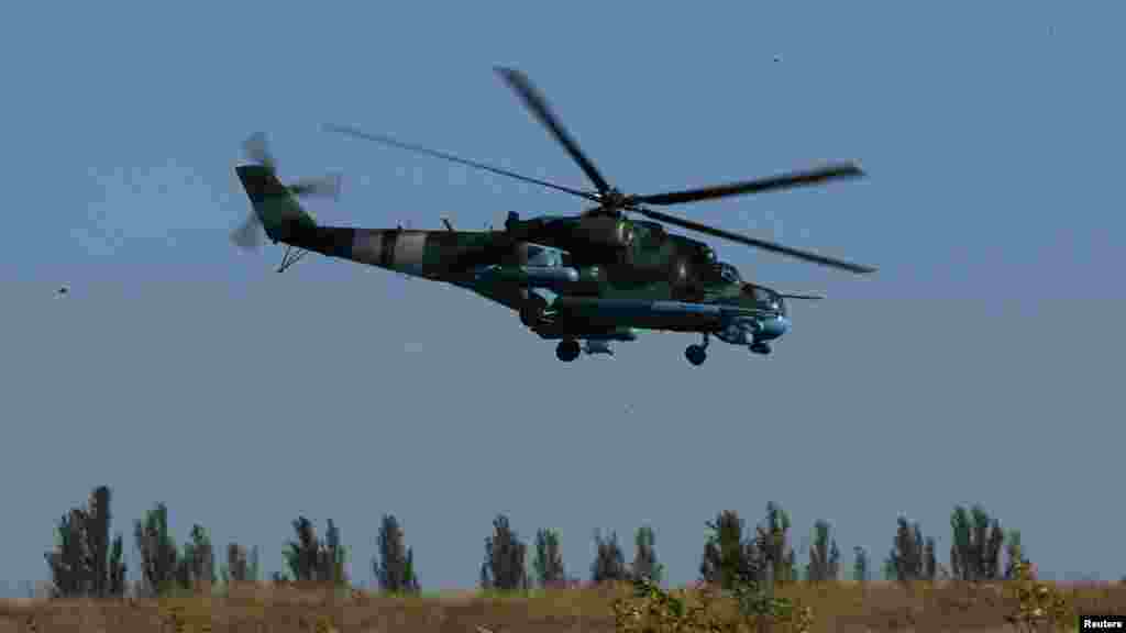 A Ukrainian Mi-24 helicopter gunship flies above a military base in the eastern Ukrainian town of Kramatorsk, Sept. 20, 2014. 