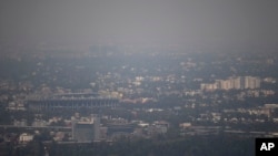 Mexico City's Azteca Stadium, left, is seen through a thick haze, Tuesday, March 15, 2016.