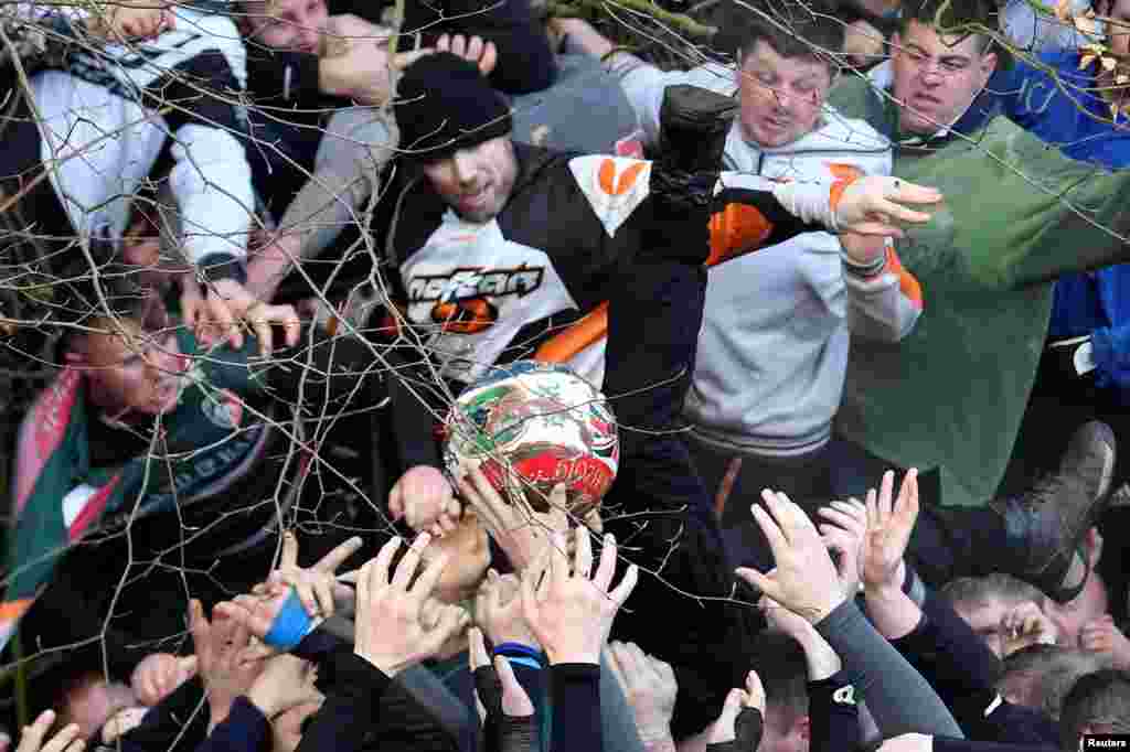 Players fight for the ball during the annual Shrovetide football match in Ashbourne, Britain.