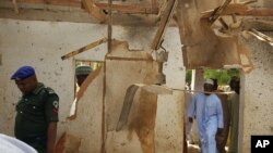 People inspect a damaged mosque following a suicide bomb explosion in Maiduguri, Nigeria on March 16, 2016. Two female suicide bombers killed at least 24 worshipers and wounded 18 in an attack during dawn prayers Wednesday on a mosque on the outskirts of the northeast Nigerian city of Maiduguri, the city that is the military command center of the war against Boko Haram Islamic insurgents. 