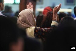 A woman prays during Mass at St. Mary's Catholic Church in Dubai, United Arab Emirates, Sunday, Jan. 20, 2019.