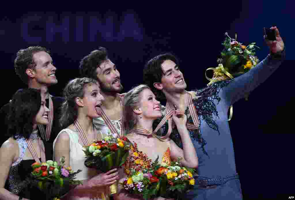 (L-R) Silver medalists Madison Chock and Evan Bates of the US, gold medalists Gabriella Papadakis and Guillaume Cizeron of France and bronze medalists Kaitlyn Weaver and Andrew Poje of Canada pose during the awards ceremony of the ice dance of the 2015 ISU World Figure Skating Championships at Shanghai Oriental Sports Center in Shanghai.