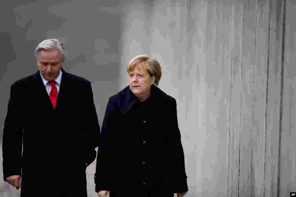 Kanselir Jerman&nbsp;Angela Merkel, kanan, dan Walikota Berlin, Klaus Wowereit berjalan di sepanjang reruntuhan Tembok&nbsp;Berlin di lokasi monumen&nbsp;Tembok&nbsp;Berlin di Bernauer Strasse,&nbsp;Berlin, Jerman. 