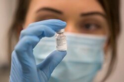 Seorang nakes memegang sebotol vaksin Pfizer-BioNTech COVID-19, saat berlangsungnya program vaksinasi massal di Rumah Sakit Southmead di Bristol, Inggris, Selasa 8 Desember 2020.