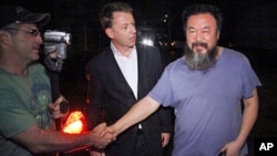 Activist artist Ai Weiwei (R) shakes hand with unidentified foreign journalists gathered outside his home in Beijing, June 22, 2011