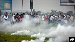'Union for Democracy and Social Progress' supporters flee after tear gas canisters were used by police to disperse them near Ndjili airport in Kinshasa, DRC, November 26, 2011.