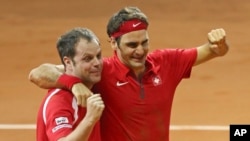 Swiss coach Severin Luthi (L) and Switzerland's Roger Federer celebrate after Federer defeated France's Richard Gasquet in the Davis Cup final in Lille, northern France, Nov. 23, 2014.