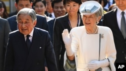 FILE - Japan's Emperor Akihito (left) and Empress Michiko walk into the compound of the memorial house of Vietnam's nationalist Phan Boi Chau (1867-1940), in the central city of Hue, Vietnam's former imperial city, March 4, 2017.