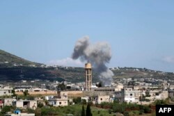 FILE - Smoke billows following bombardment by regime forces on the village of Basamis, Idlib province, Syria, May 4, 2019.