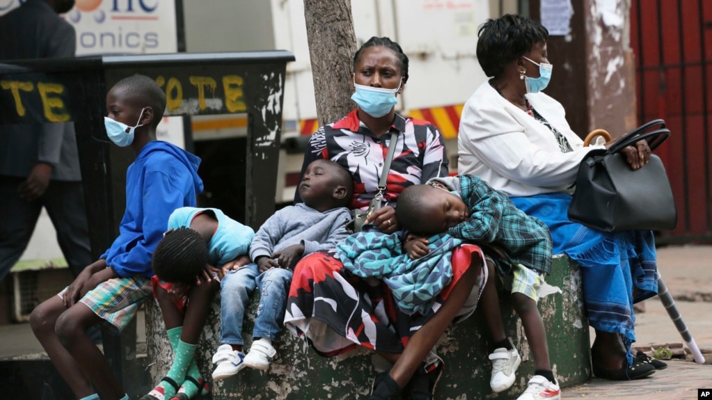 A mother takes time to rest with her children in Harare, Zimbabwe, Nov, 26, 2021. A slew of nations have moved to stop air travel from southern Africa, and stocks have plunged in Asia and Europe in reaction to news of a new, potentially more transmissible COVID-19 variant. 