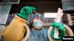 北京一名醫護人員正在給居民進行新冠病毒核酸檢測。 （2021年10月20日）