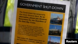 A security officer holds a sign informing people on the government shutdown of Alcatraz Island, a tourist attraction operated by the National Park Service, in San Francisco, California, Oct. 1, 2013. 