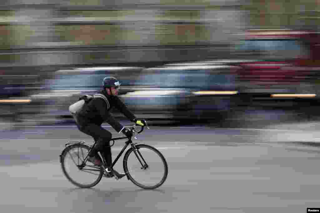 A Commuter cycles in central London. The deaths of five cyclists in just nine days on the roads this month in London have prompted calls for the city's mayor Boris Johnson to speed up road safety measures in the capital. The fatalities have been caused through collisions with buses, trucks and a coach.