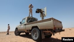 FILE - Libyan forces allied with the U.N.-backed government patrol to prevent Islamic State resurgence on the outskirts of Sirte, Libya, Aug. 4, 2017. A mass grave of suspected IS fighters was found in the area last week.
