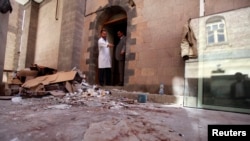 Seorang dokter dan korban yang selamat dari serang bom di lokasi serangan bom di rumah sakit, Yaman.