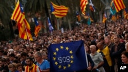 Pro-independence supporters hold a European Union flag during a rally in Barcelona, Spain, Oct. 10, 2017. Catalan President Carles Puigdemont said during his speech in the parliament that the region remained committed to independence but said it should follow dialogue with the government in Madrid. 