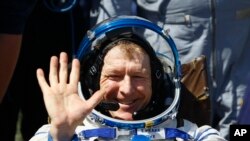 Salah seorang kru pesawat antariksa Intarnasional (ISS), Tim Peake (astronot Inggris) melambaikan tangannya seusai mendarat dengan parasut di dekat kota Dzhezkazgan, Kazakhstan (18/6).