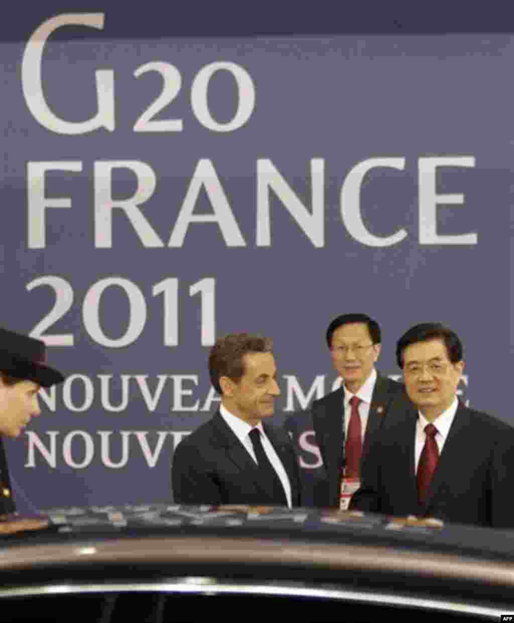 Chinese President Hu Jintao, right, and French President Nicolas Sarkozy, center, smile after a meeting at the G20 summit in Cannes, Wednesday Nov.2, 2011. Greek Prime Minister George Papandreou arrived to the chic French Riviera resort of Cannes to expl