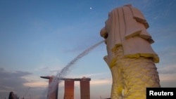 FILE - The Merlion statue overlooking the Marina Bay area spouts water as the Marina Bay Sands resort and casino is pictured in the background.