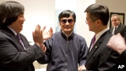 In this photo released by the U.S. Embassy Beijing Press Office, blind lawyer Chen Guangcheng is wheeled into a hospital by U.S. Ambassador to China Gary Locke, right, and an unidentified official at left, in Beijing, May 2, 2012. 