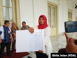 Baiq Nuril memperlihatkan salinan amnesti dari Kemenkumham kepada awak media, di Istana Keprsidenan Bogor, Bogor, Jumat, 2 Agustus 2019. (Photo: VOA/Ghita).