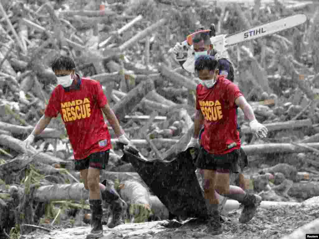 Rescuers carry a body bag containing bodies of typhoon victims recovered from the debris swept by floodwaters at the height of Typhoon Bopha, in New Bataan town in Compostela Valley, southern Philippines December 7, 2012. Residents in the southern Philipp