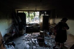 Ayelet-Chen Wadler, a member of the Torah Nucleus community, walks through the torched apartment of a Jewish family after recent clashes between Arabs and Jews. (AP Photo/David Goldman)