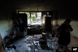 Ayelet-Chen Wadler, a member of the Torah Nucleus community, walks through the torched apartment of a Jewish family after recent clashes between Arabs and Jews. (AP Photo/David Goldman)