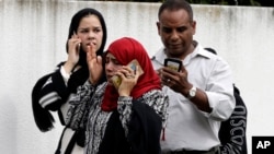 People wait outside a mosque in central Christchurch, New Zealand, March 15, 2019.