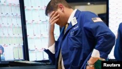 Un operador de bolsa en Wall Street reacciona abatido ante el desplome de las acciones.