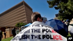 在2020年6月3日鳳凰城的抗議活動中，抗議者身披要求取消當地警察局的橫幅（美聯社）。
