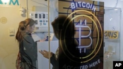 FILE - People use a bitcoin ATM in Hong Kong, Dec. 8, 2017.