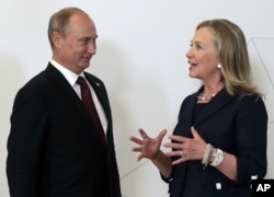 FILE - Russian President Vladimir Putin meets then-U.S. Secretary of State Hillary Clinton on her arrival at the APEC summit in Vladivostok, Russia, Sept. 8, 2012.