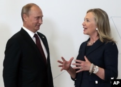 Russian President Vladimir Putin, left, meets then U.S. secretary of state Hillary Rodham Clinton on her arrival at the APEC summit in Vladivostok, Russia, Sept. 8, 2012.