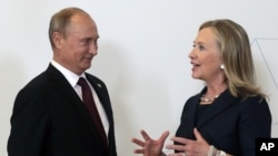 Russian President Vladimir Putin, left, meets U.S. Secretary of State Hillary Rodham Clinton on her arrival at the APEC summit in Vladivostok, Russia, Sept. 8, 2012.