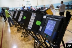 FILE - Electronic voting machines in Columbus, Ohio, Nov. 3, 2015.