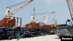 Workers offload pipes at a construction site of Dangote oil refinery in Ibeju Lekki district, on the outskirts of Lagos, Nigeria August 7, 2019. (REUTERS/Temilade Adelaja)