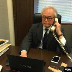 Tomohiko Taniguchi, Adviser to Cabinet of Prime Minister Abe, speaks on the phone in Tokyo, Feb. 8, 2016. (S. Herman/VOA)