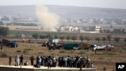 Smoke rises after Islamic State group tank fired toward city center of Kobani in Syria as fighting intensified between Syrian Kurds and the militants, seen from Mursitpinar near Suruc, Turkey, Oct. 3, 2014.