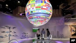 A globe with the national flags hangs in one of the pavilions at the UN Climate Conference in Bonn, Germany, Tuesday, Nov. 7, 2017. (Oliver Berg/dpa via AP)