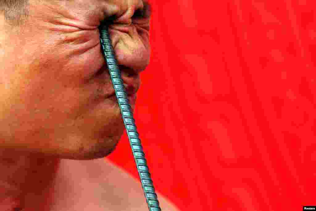 Ngo Chien Thuat, a traditional health worker, bends a metal pole by pressing it into his eye as he performs during a showcase of the traditional Thien Mon Dao kung fu at Du Xa Thuong village in Vietnam.