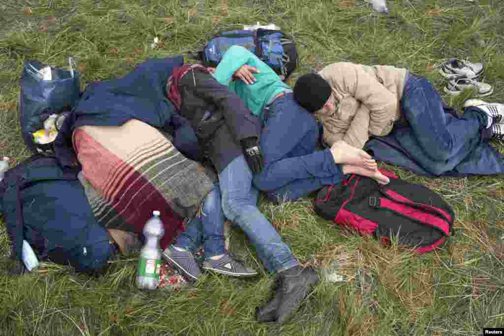 Migrants sleep in front of a registration camp in Opatovac.