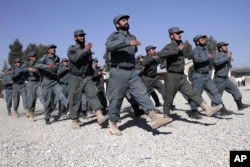 FILE - Afghan police officers march during a graduation ceremony at a national police training center in Jalalabad, east of Kabul, Afghanistan.