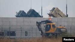 FILE - A truck moves past U.S. Army Patriot missile air defense artillery batteries at U.S. Osan air base in Osan, south of Seoul.