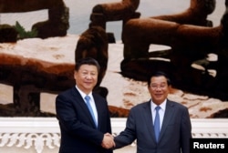 Chinese President Xi Jinping and Cambodian Prime Minister Hun Sen shake hands as they pose for a picture at the Prime Minister's office in Phnom Penh, October 13, 2016. REUTERS/Samrang Pring