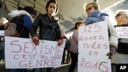 Women hold placards reading "Sexism is not my gender,“ left, and “125 women killed in 2016" during a rally protesting sexual abuse and harassment, in Marseille, southern France, Oct. 29, 2017.