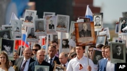 Vladimir Poutine, une photo de son père à la main. Parade militaire à la place Rouge, Moscou, Russie, le 9 mai 2016. 