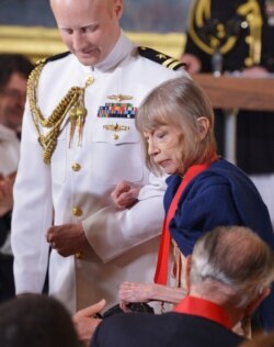 2012 National Humanities Medal recipient author Joan Didion returns to her seat after receiving her medal during a ceremony in the East Room of the White House on July 10, 2013.